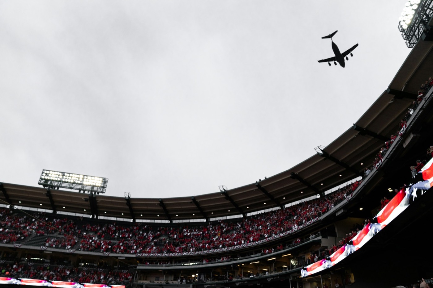 A plane flying over the packed stands of Angel Stadium on game day