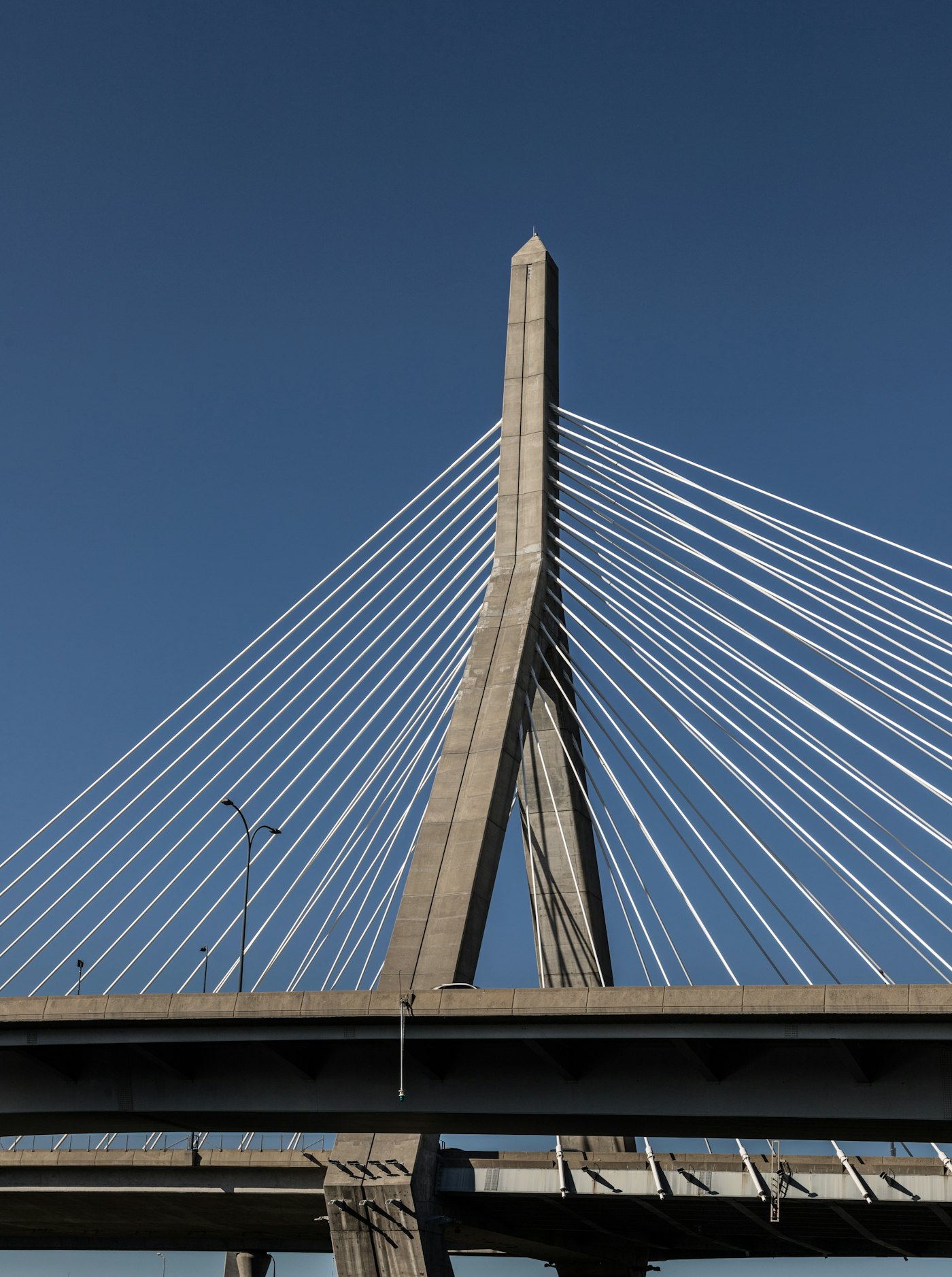 The tower and cables of the Zakim Bridge against a clear blue sky
