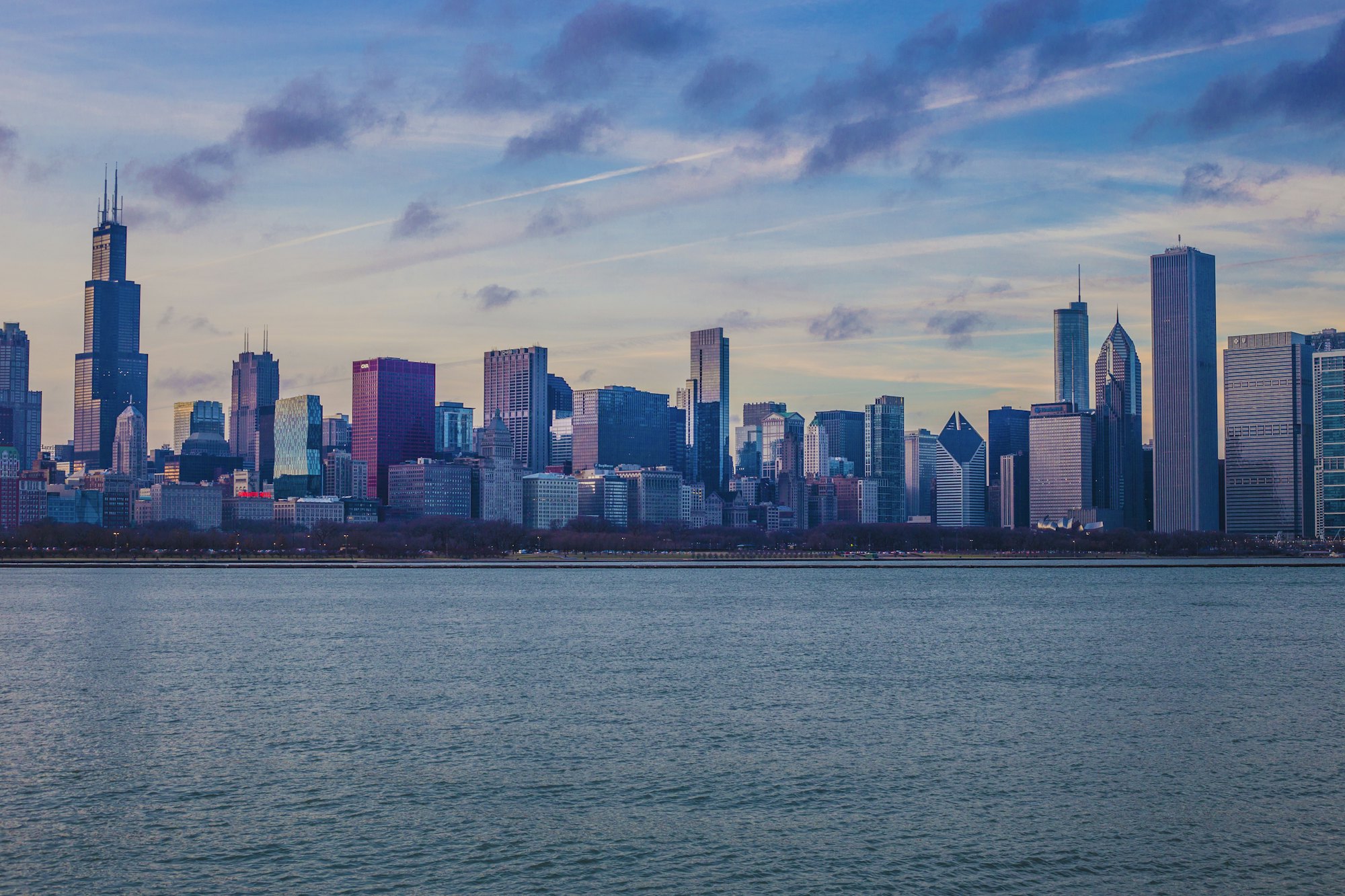 The Chicago skyline with Willis Tower across Lake Michigan at dusk