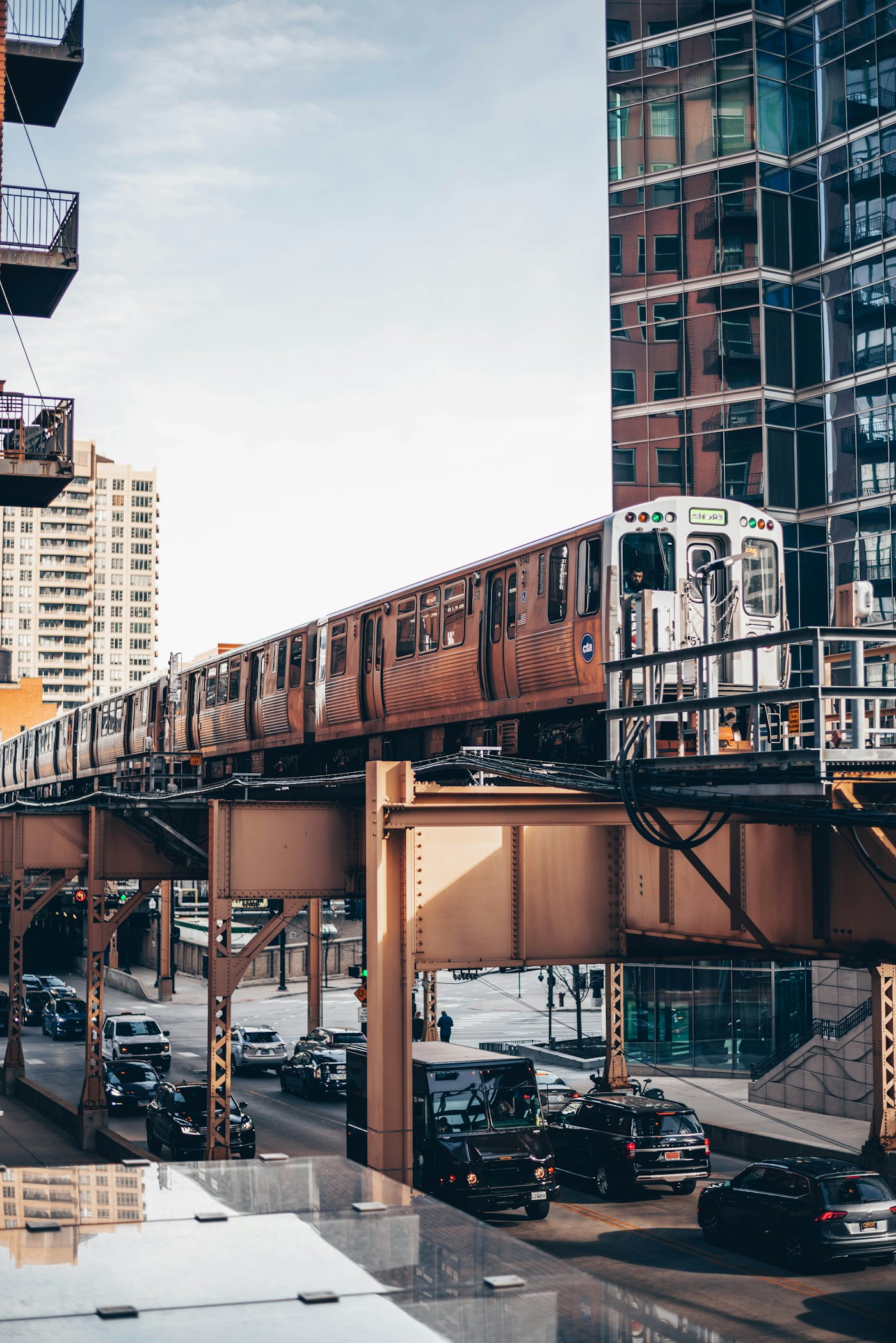An L train running on the elevated tracks between downtown Chicago buildings
