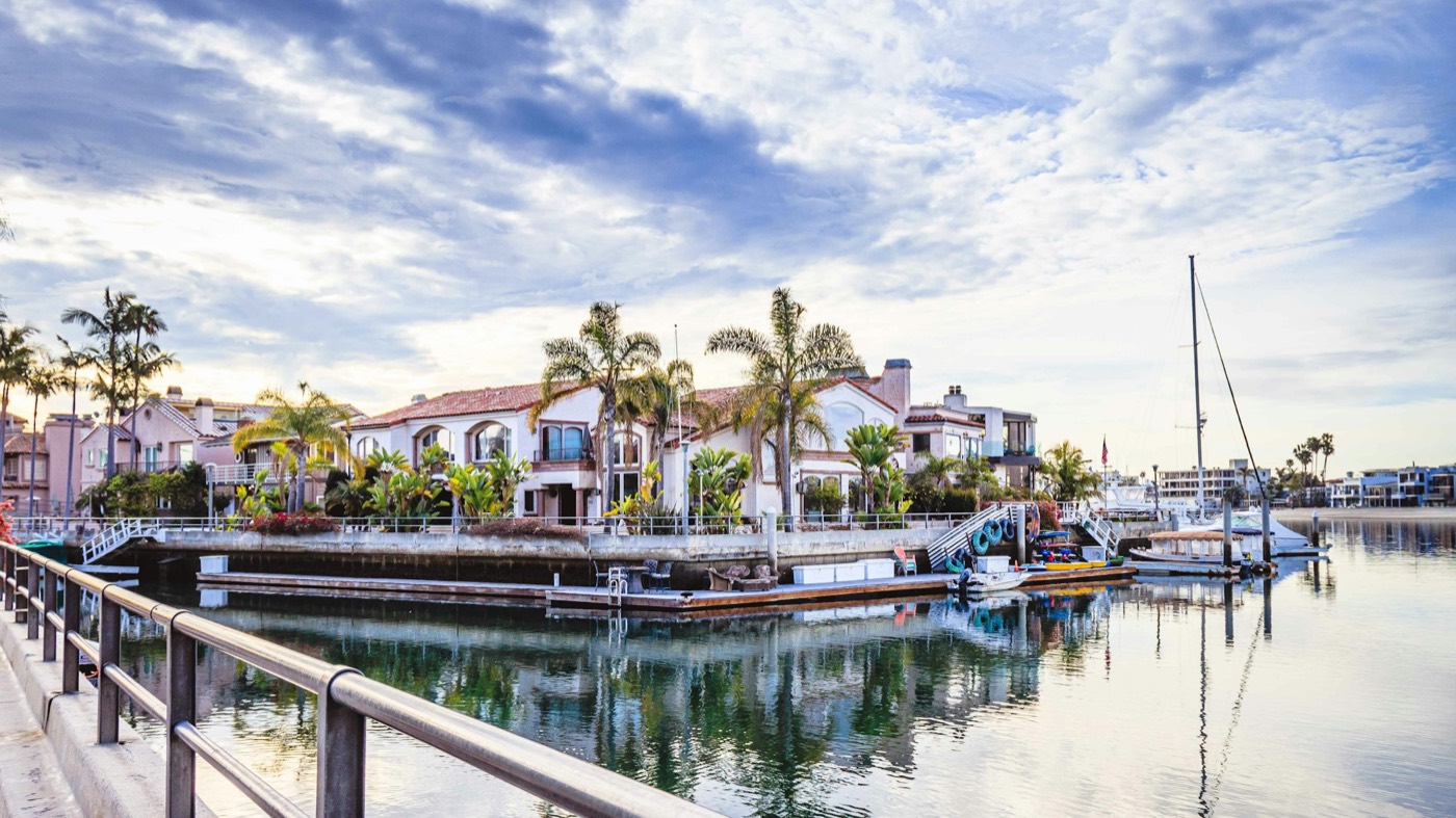 Waterfront homes with palm trees and private docks along a canal in Long Beach
